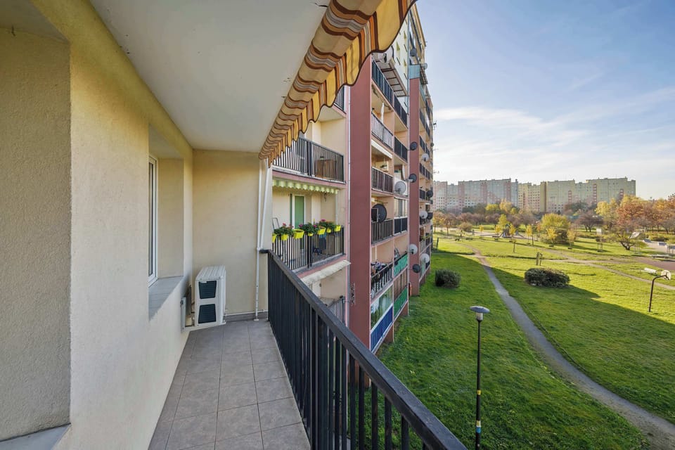 Another angle from the balcony showing the same view under bright sunlight. The railing and flooring look well-maintained.