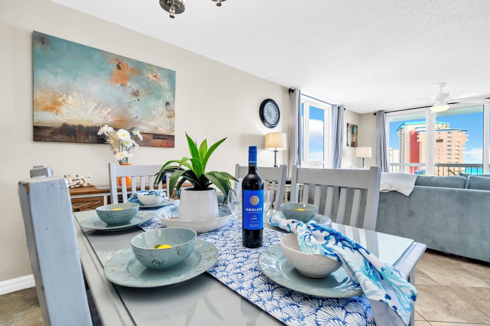 Gather around your beautifully set dining table with coastal touches and enjoy meals with stunning city views through expansive windows.