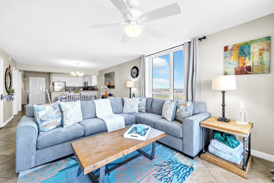 Relax in your spacious living room with plush sectional seating, modern décor, and beautiful natural light streaming through large windows.
