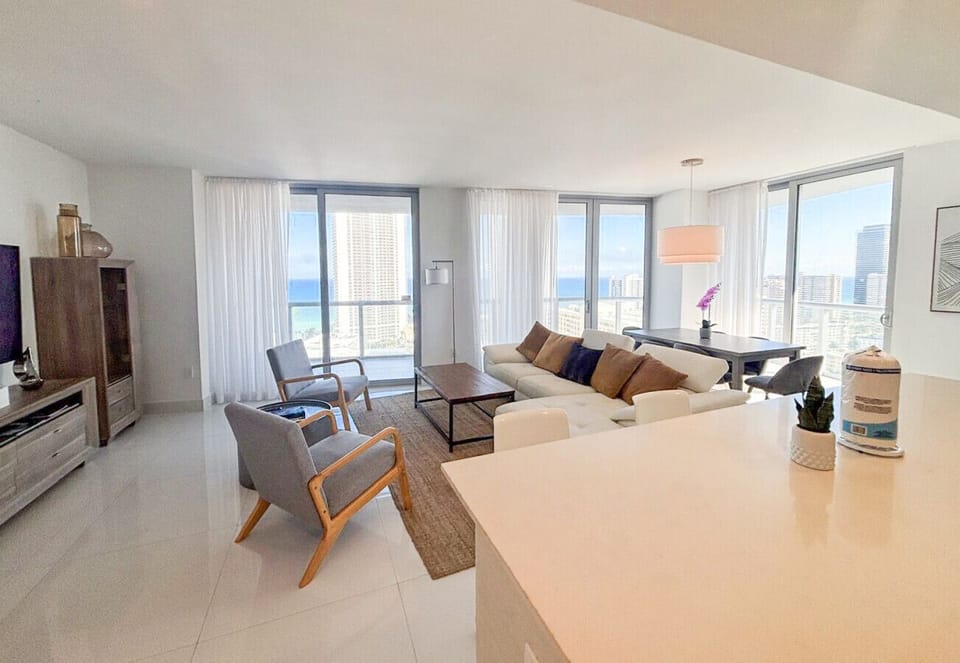 Bright living room with balcony access and city views.