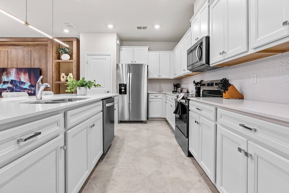 Welcome to a bright kitchen ideal for culinary adventures, complete with pristine white cabinetry and sleek stainless steel appliances. Enjoy the natural light that fills the space, creating an inviting atmosphere for meal prep.