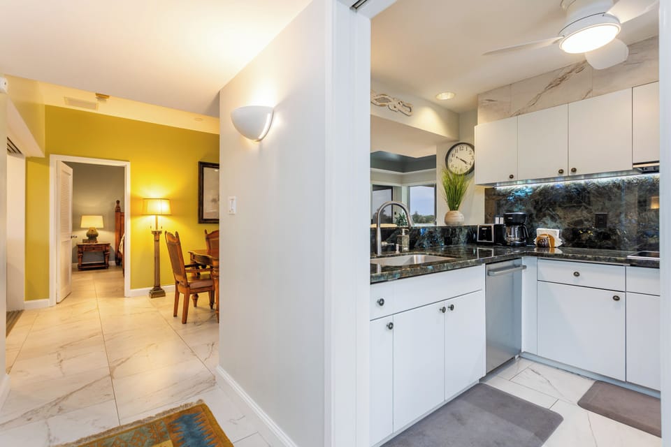 Step into this bright, open-plan space where sunny yellow walls welcome you home. Your modern kitchen awaits with sleek white cabinetry, marble counters, and everything you need to whip up a meal after a day of adventure.
