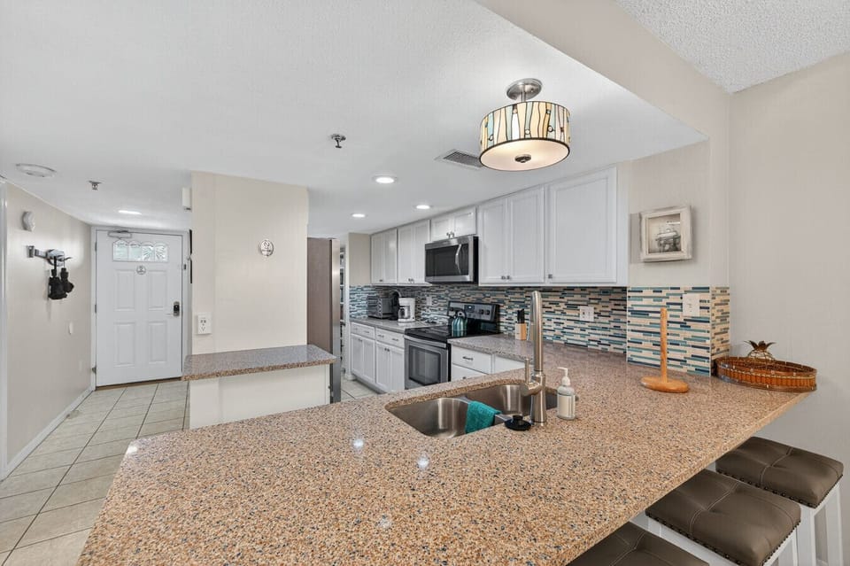 Kitchen detail showcasing granite counters and stainless appliances ready for home-cooked meals.