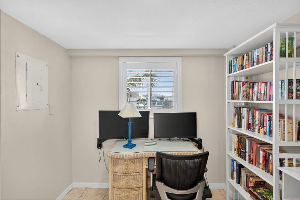 Cozy office nook w/ desk and shelving, perfect for remote work or quiet planning time.