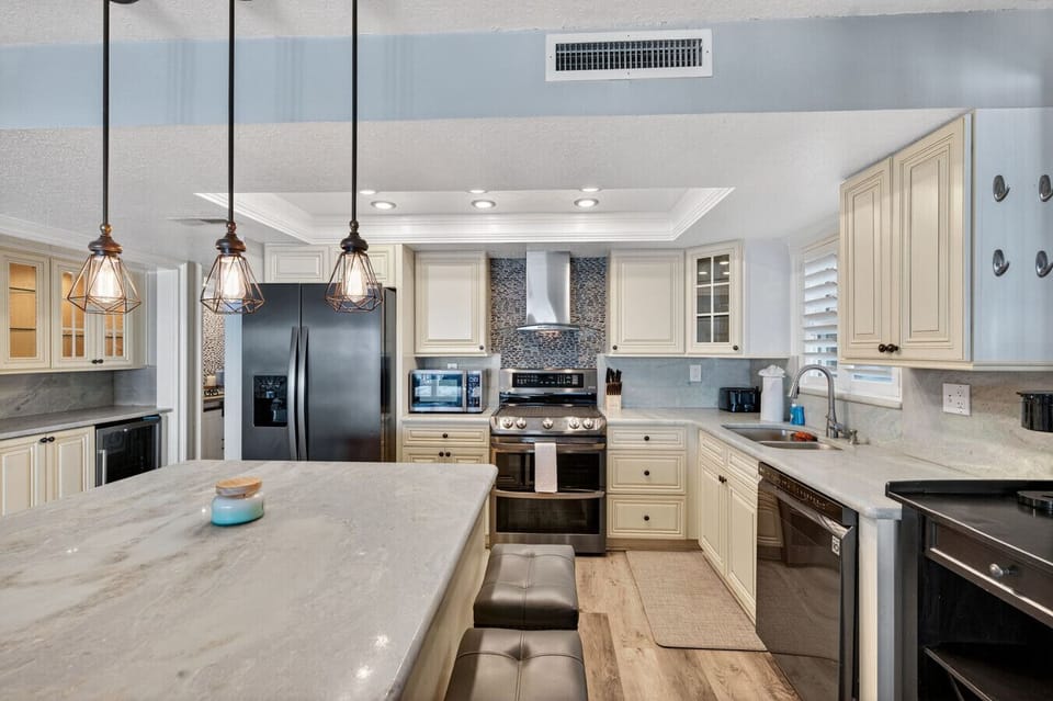 Spacious kitchen w/ island seating & modern finishes, great for cooking & gathering together.