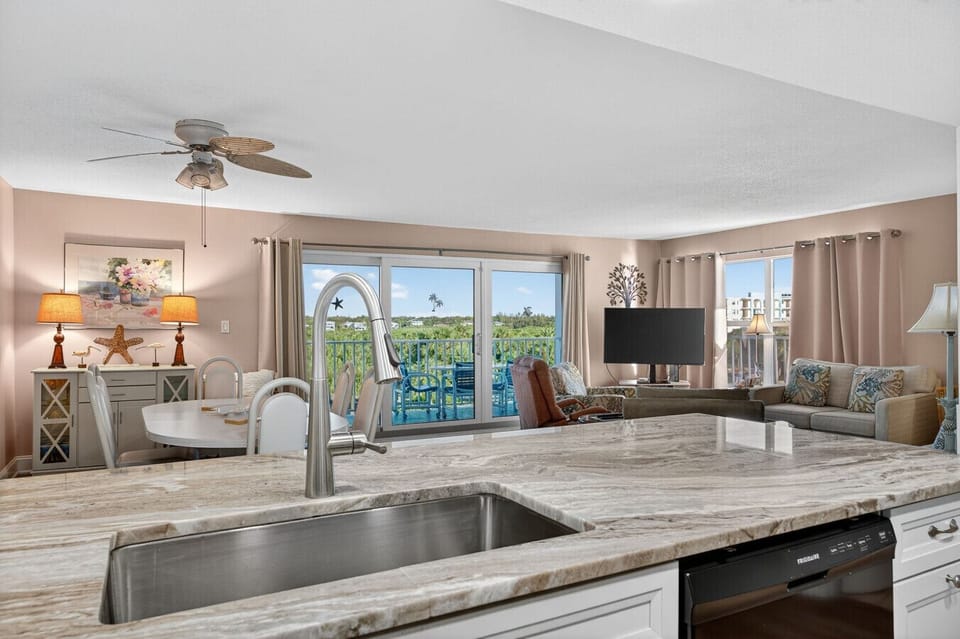 Kitchen sink view opening to the living area, keeping conversations flowing while you prep or clean up