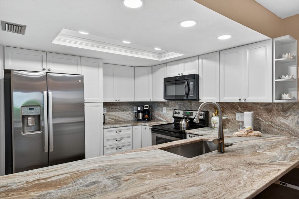 Spacious kitchen island w/ stone countertops, modern sink & plenty of prep space for shared meals