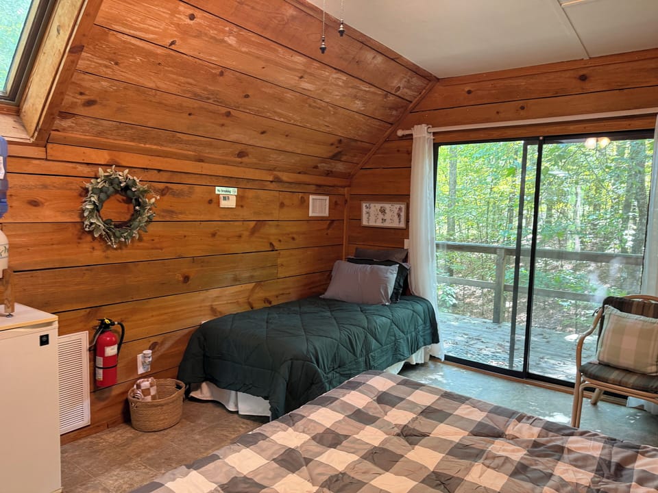 Twin bed with wooded views through the sliding glass doors