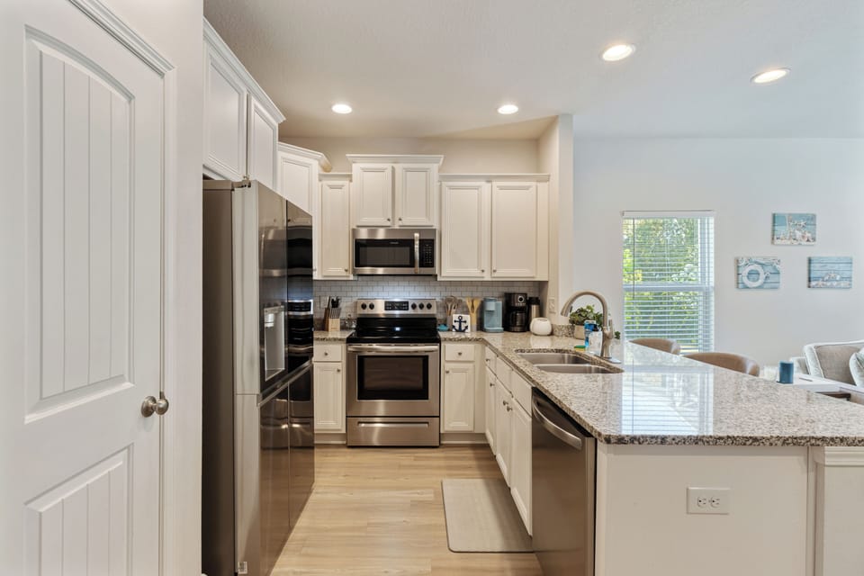 Modern, fully equipped kitchen with stainless steel appliances, granite countert