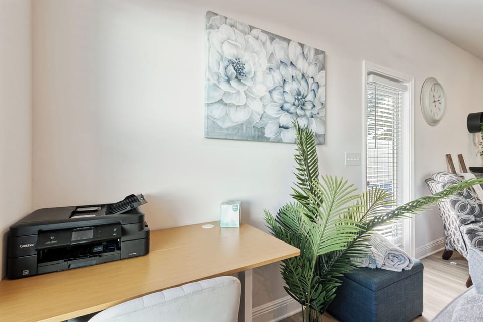 Dedicated workspace area with desk, chair, and printer perfect for remote work 