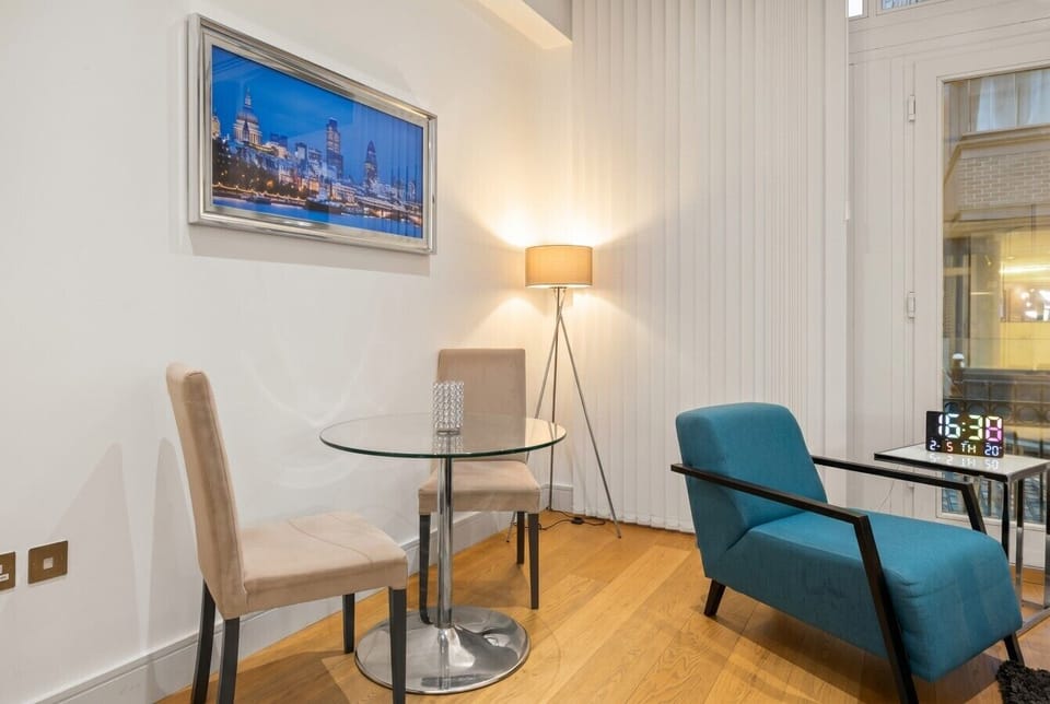 Cozy dining nook with London skyline art and reading lamp.