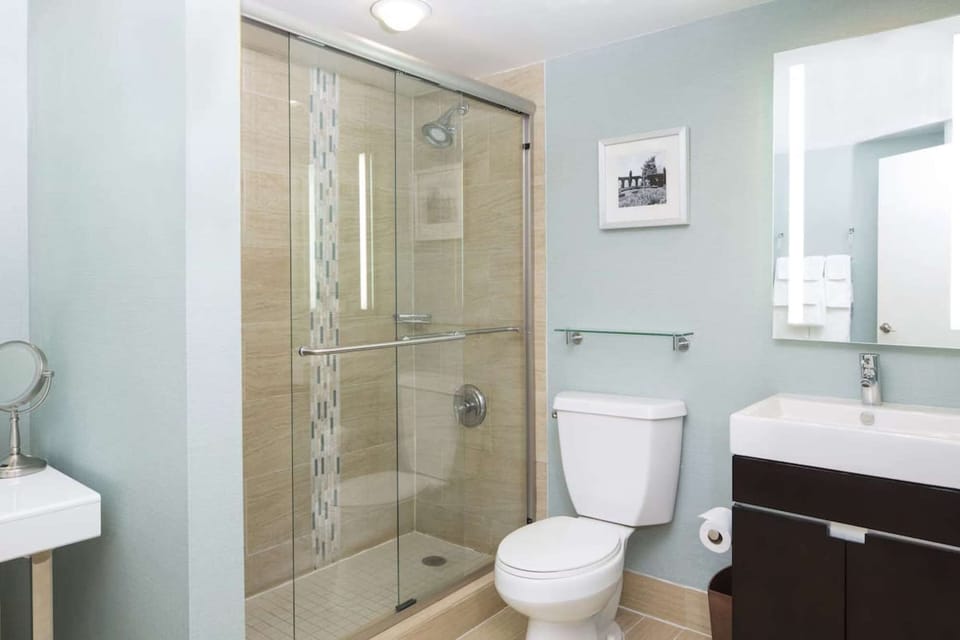 Clean bathroom with glass shower and bright mirror