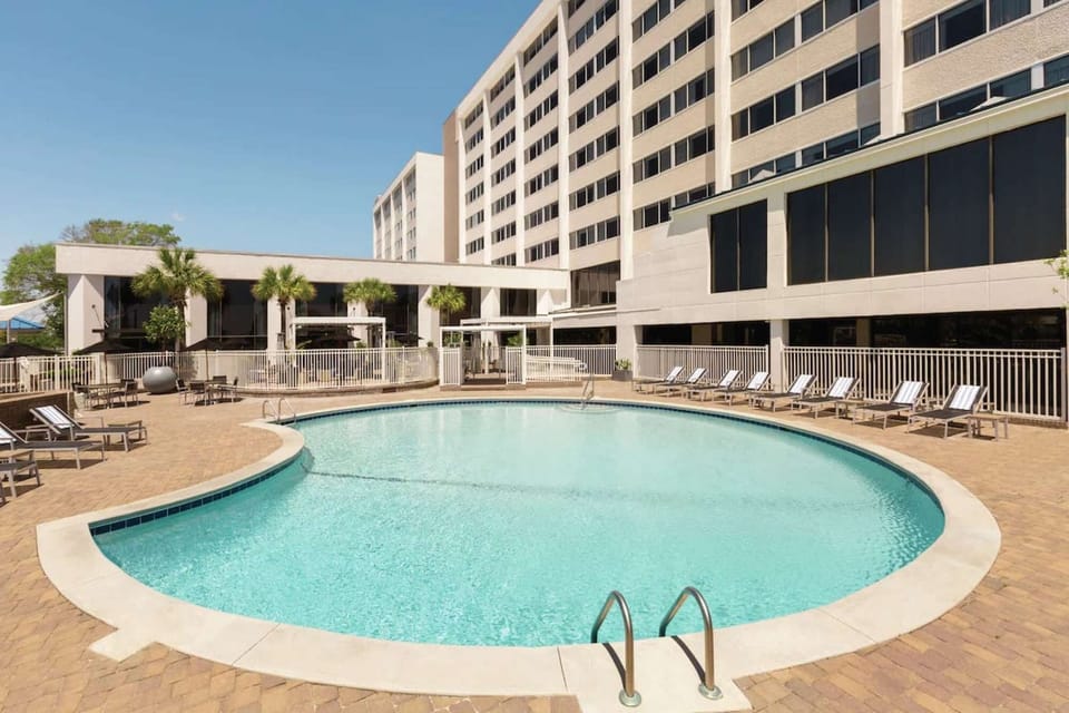 Outdoor pool area with lounge chairs and palm trees