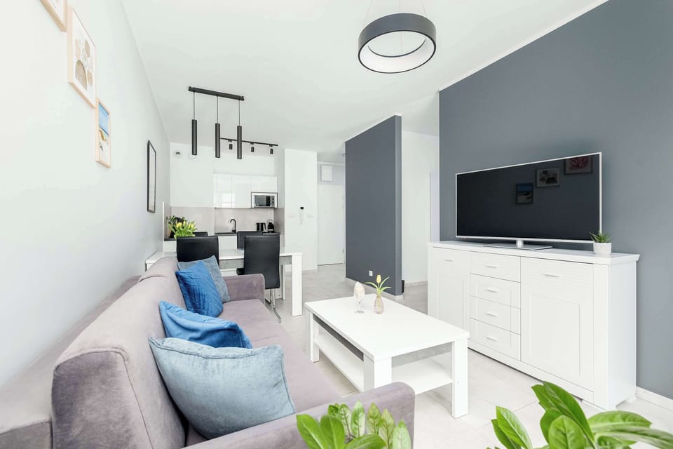 Bright and inviting living room with a comfortable sofa, modern coffee table, and flat-screen TV — perfect for relaxing after a long day.