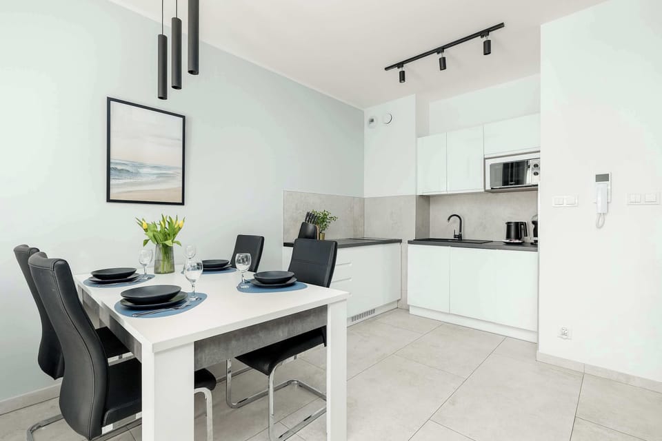 Dining corner with a mirror, elegant chairs, and minimalist décor — ideal for small gatherings or quiet meals.