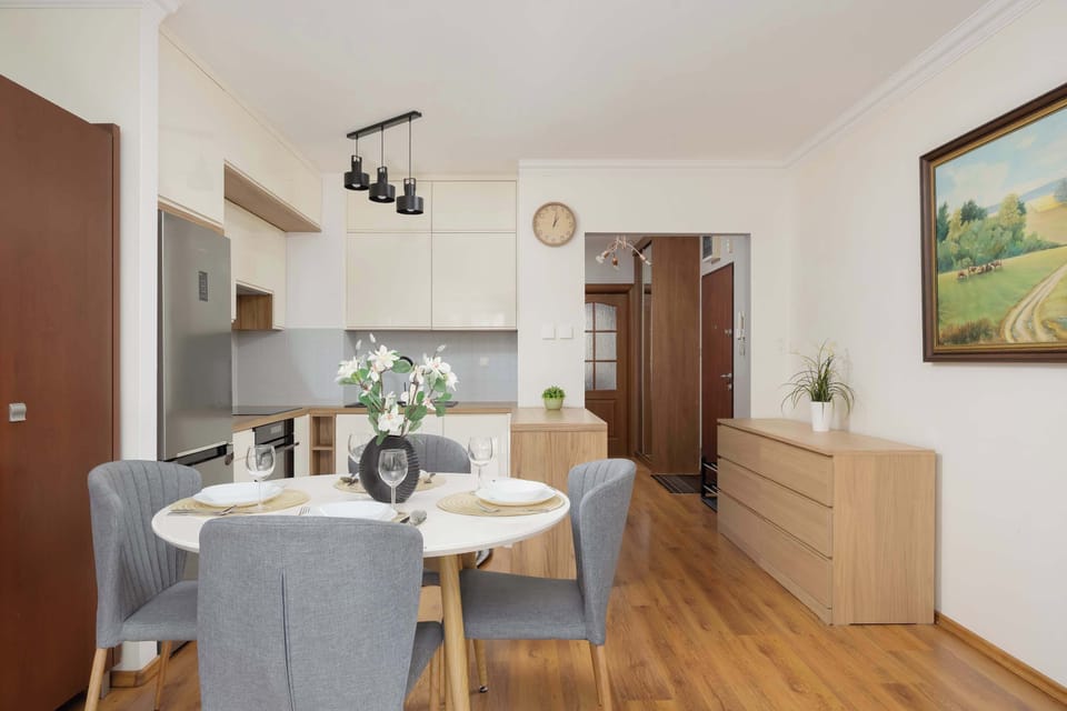 The bright living area with a kitchen and dining table creates a welcoming space for shared meals and conversations in natural light.