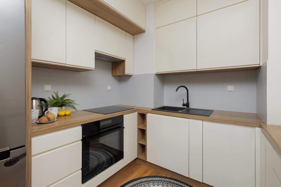 Modern kitchen with bright cabinets and black fittings combines aesthetics with functionality, perfect for preparing meals in a calm atmosphere.