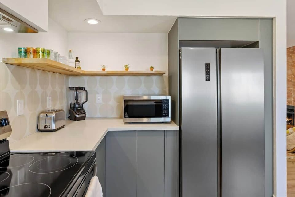 Kitchen includes most major appliances - blender, microwave, dishwasher, electric stove, oven, toaster, coffee maker w/ grinder, fridge, and even a flip style waffle maker 