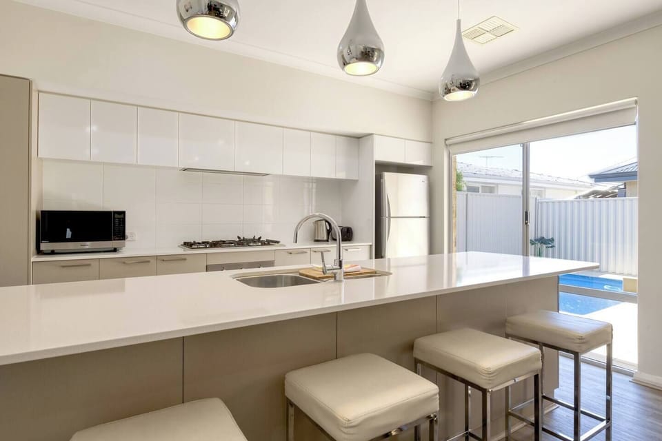 The sleek kitchen is designed around a central island, perfect for preparing meals at home.
