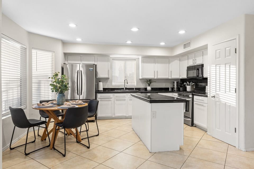 Full kitchen, stainless appliances, open to dining area.