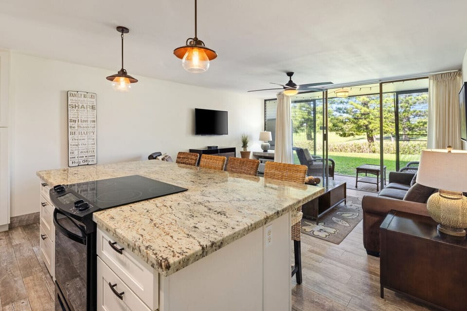 Spacious kitchen w/ big island flowing seamlessly into the bright living area.