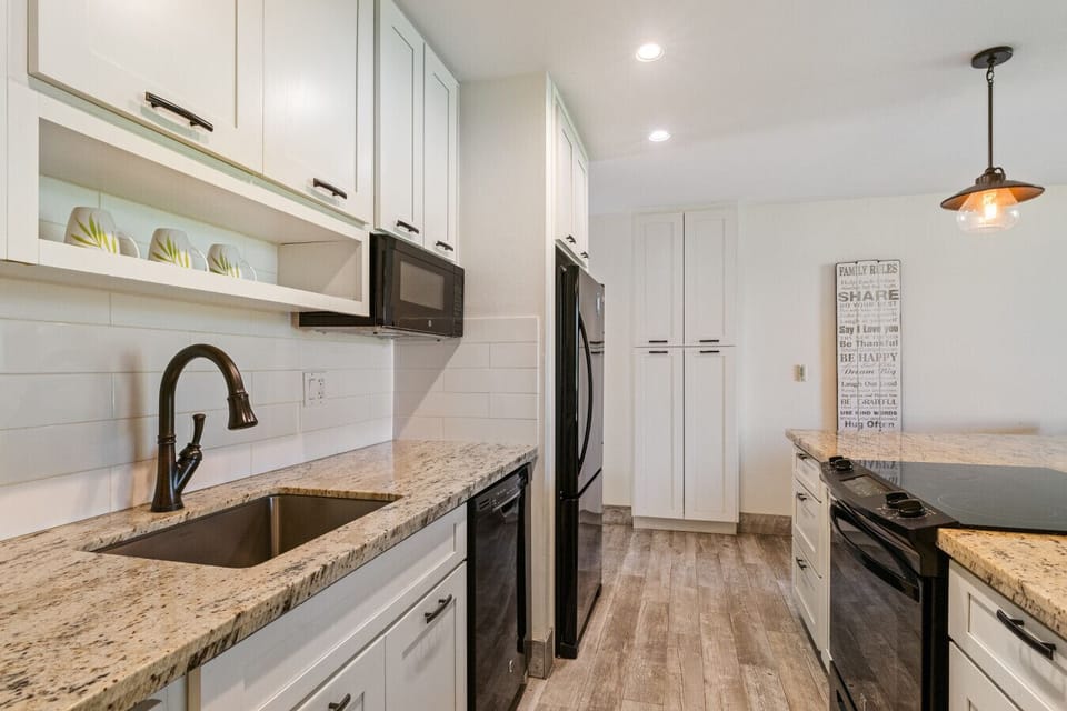 Sleek galley kitchen w/ modern fixtures ready for easy vacation cooking.