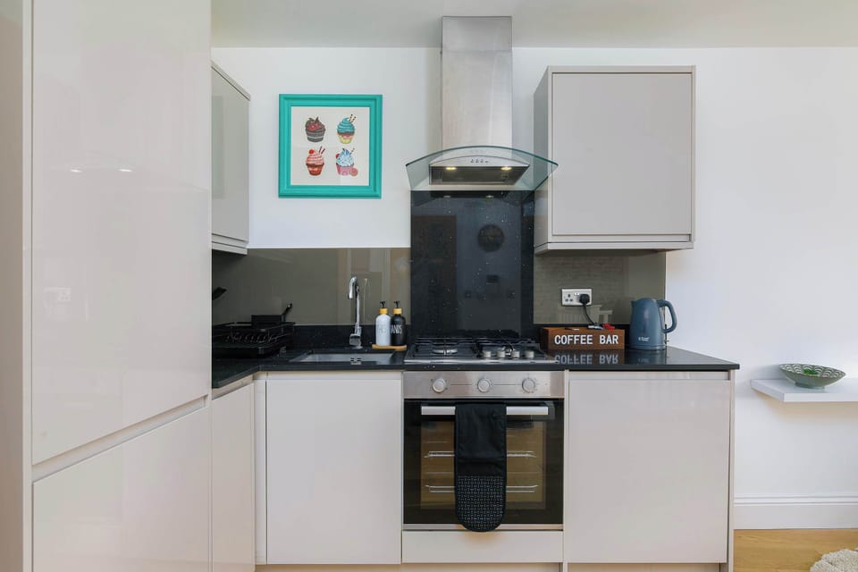 Sleek modern kitchen with oven, hob, and coffee bar — ideal for home-cooked dinners during your Shoreditch stay.