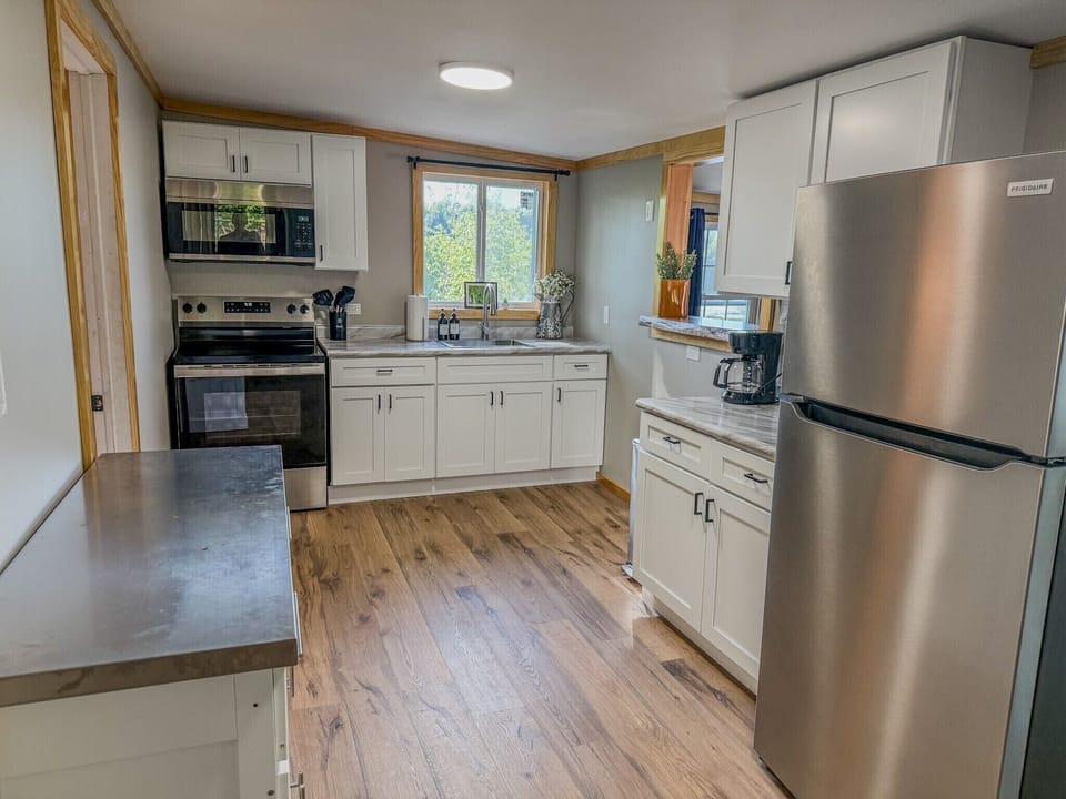 Bright modern kitchen with stainless appliances and sunny window views