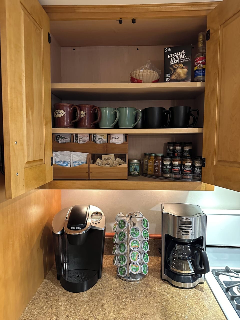 Coffee bar equipped with keurig cups, teas, hot chocolate and spices for cooking