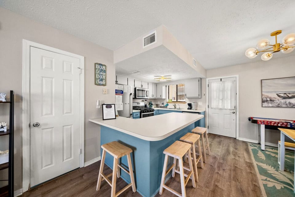 Kitchen Bar: Spacious kitchen with large breakfast bar, stainless appliances, and seating for four