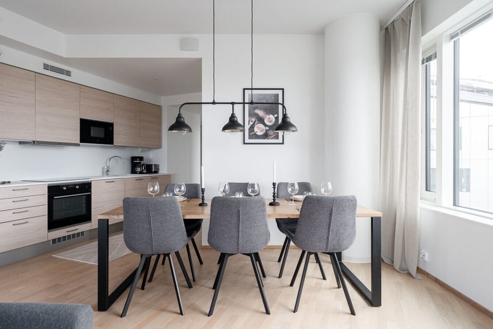 The kitchen opens up to a stylish dining area with seating for six, where you can enjoy your meals while admiring the stunning cityscape through large windows. It’s a wonderful spot for a relaxed breakfast or a cozy dinner with friends.