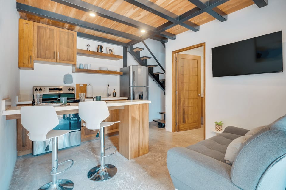 Open plan living and kitchen — high-top bar seating, Smart TV, stairs