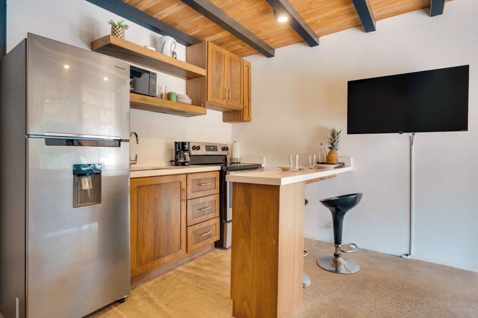 Kitchen with bar stool seating and refrigerator.