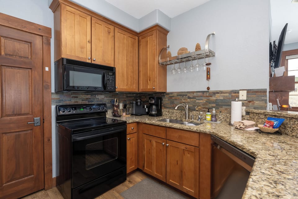 Your fully equipped kitchen at Kicking Horse Buckskin 3-205 features warm wood cabinets, granite counters, and everything you need to create memorable meals together.