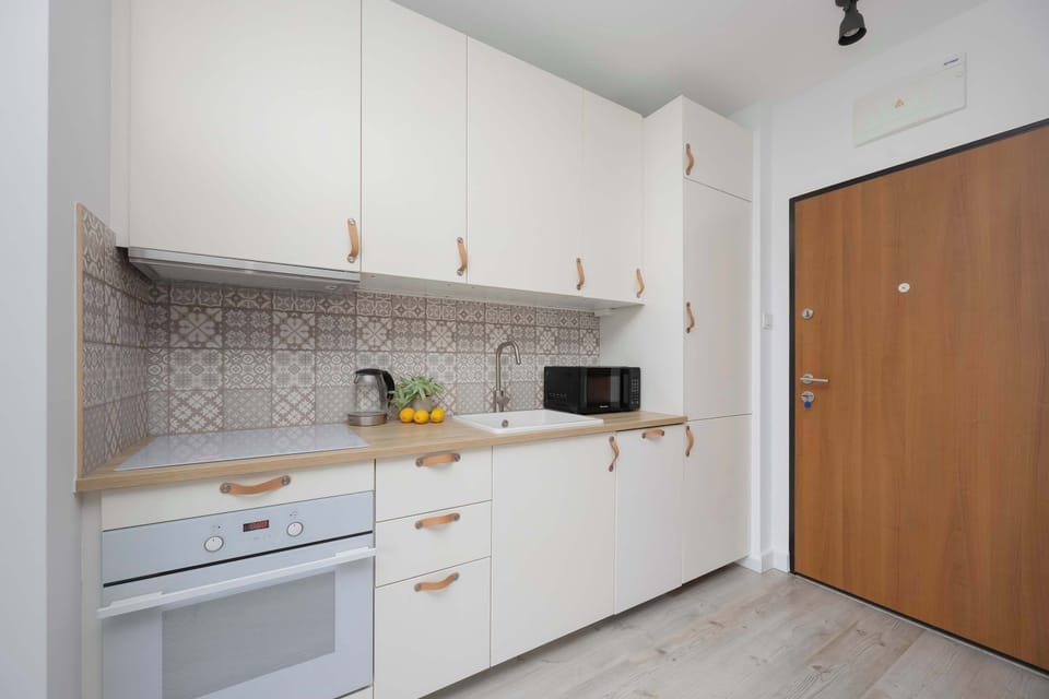 A stylish entrance with functional cabinetry and an elegant mosaic wall combines aesthetics with practicality right from the doorstep.
