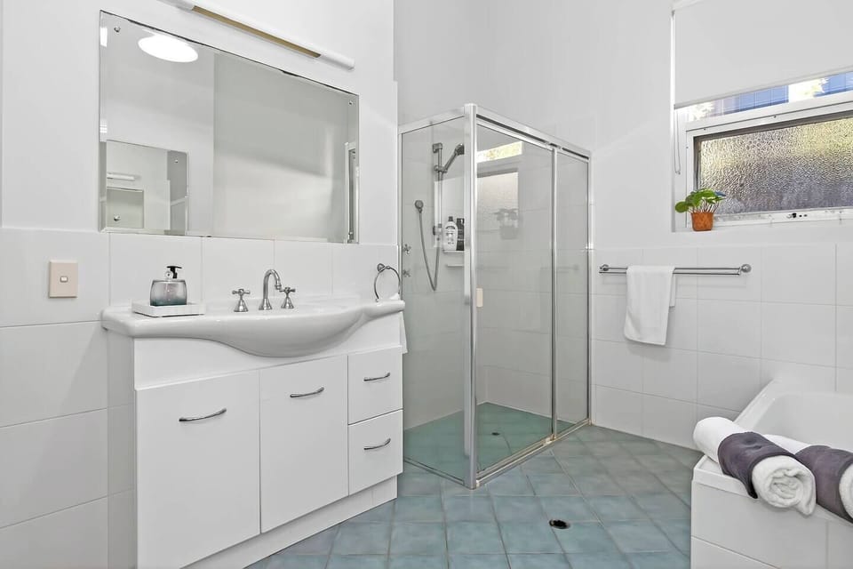 Refresh in the family bathroom, complete with a walk-in shower, deep bath, and vanity essentials.