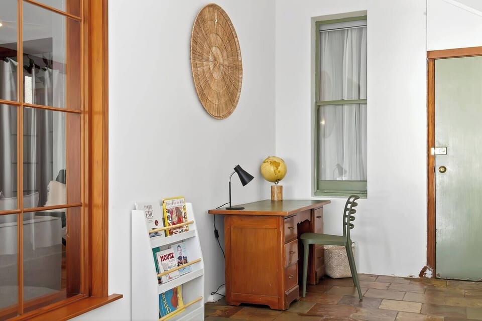 Catch up on work or plan your days from the quiet workspace, where a timber desk, reading lamp, curated décor, and soft natural light create a calm setting for focused moments.