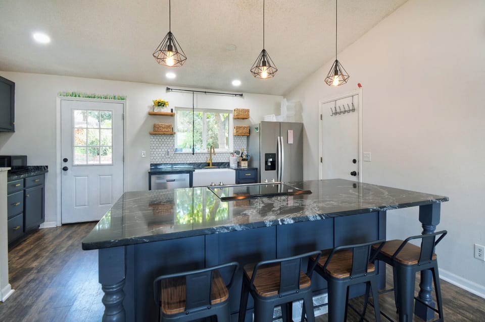Step into your dream kitchen where modern style meets farmhouse charm. Stunning geometric pendant lights illuminate the spacious island perfect for morning coffee or evening conversations.