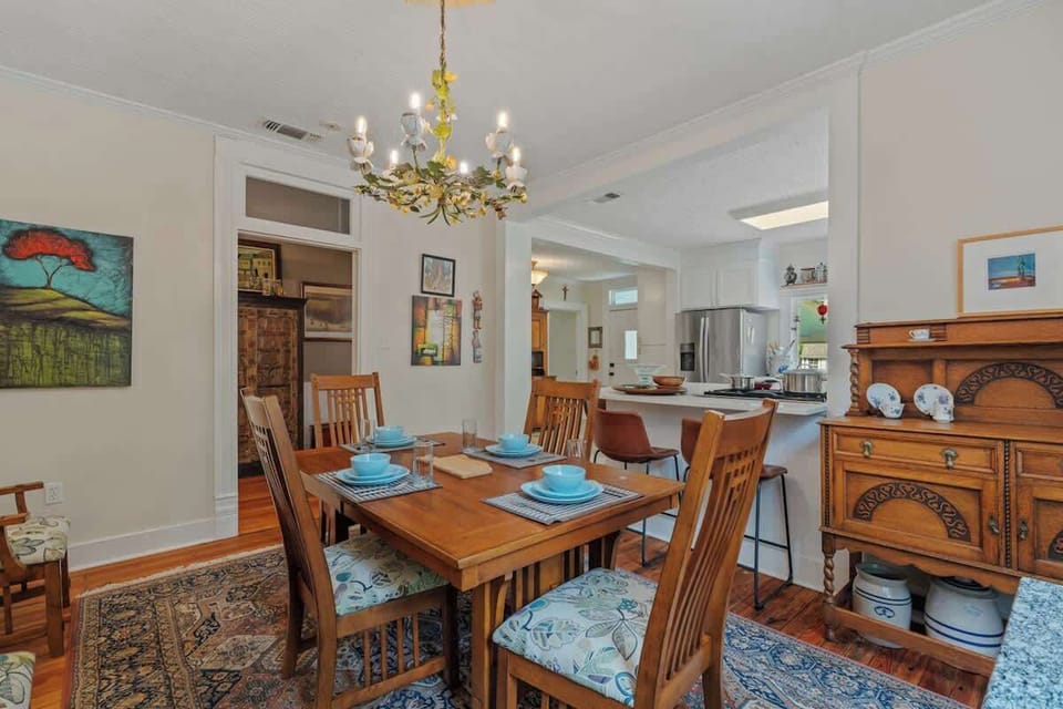 Stylish Dining Room with Buffet Storage & Kitchen View.  This beautifully styled dining room features elegant buffet cabinets, perfect for serving and storage, all set beneath curated décor that brings warmth and sophistication to the space.