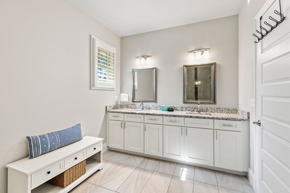 Your spacious bathroom features elegant granite countertops, dual sinks, and coastal-inspired touches for ultimate comfort.