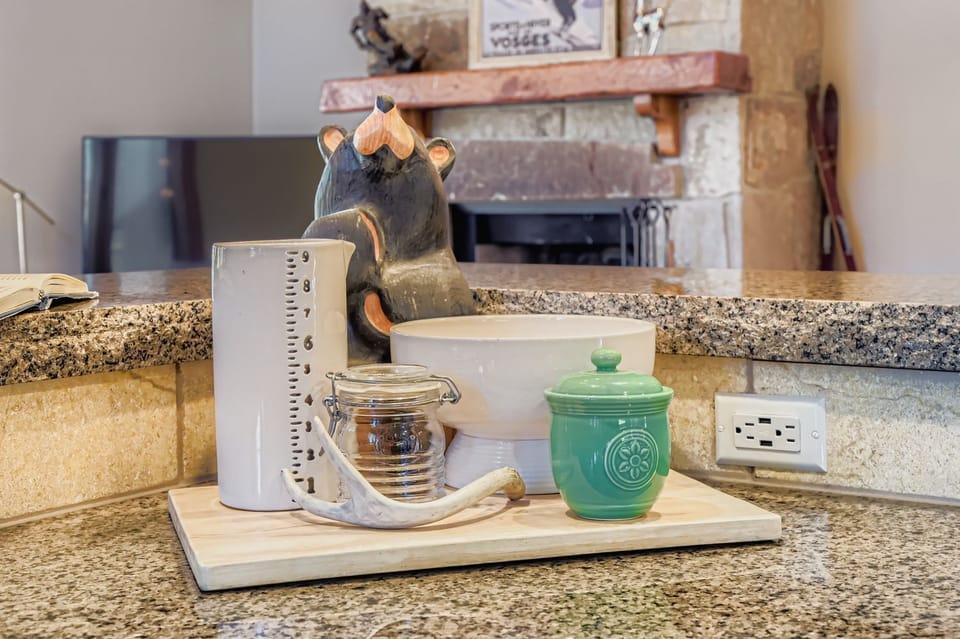 Cook in a gourmet rustic kitchen! Featuring stunning granite countertops, high-end stainless steel appliances, custom knotty-wood cabinetry, and unique bear-themed bar stools.