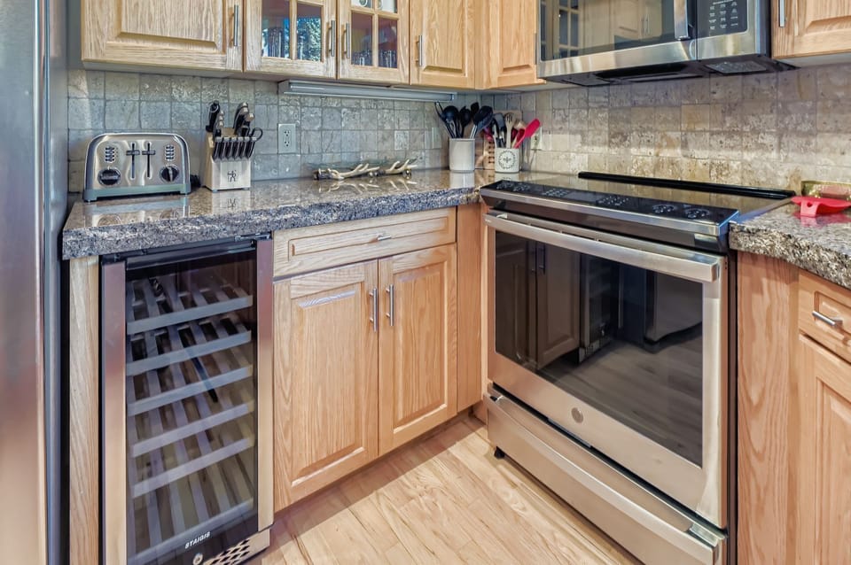 Cook in a gourmet rustic kitchen! Featuring stunning granite countertops, high-end stainless steel appliances, custom knotty-wood cabinetry, and unique bear-themed bar stools.