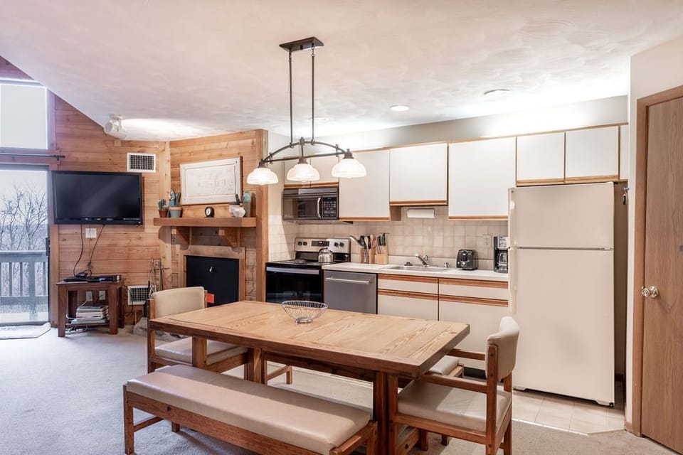 Bright kitchen and dining area where rustic touches meet mountain charm, creating the perfect setting for shared meals and memories.