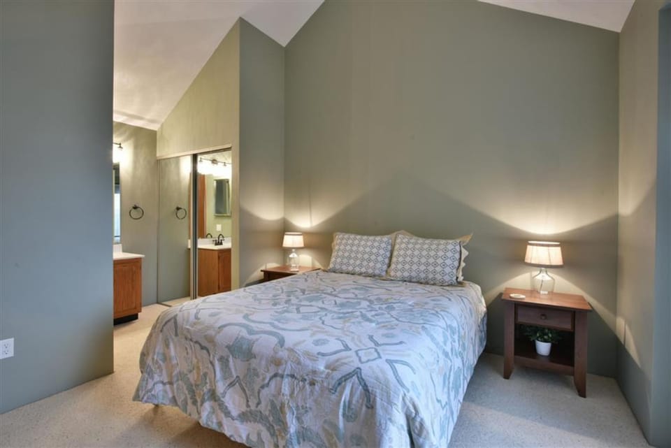 Inviting upstairs bedroom with plush queen bed and ensuite bathroom for added convenience.
