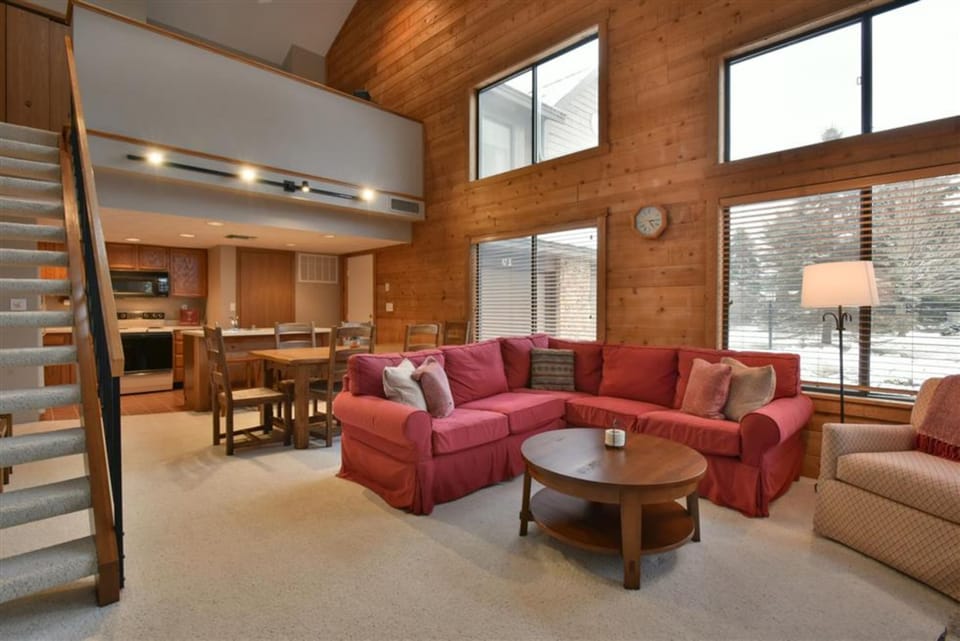 Open-concept main level with rustic charm, combining living, dining, and easy access to the loft.