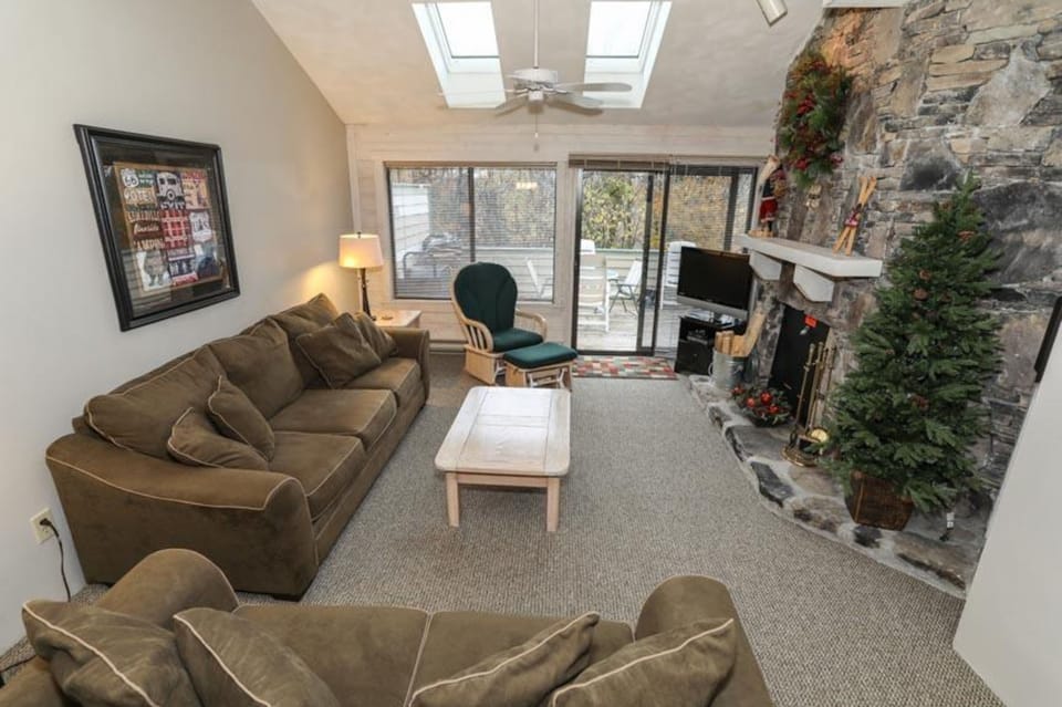 Bright living room with vaulted ceilings, fireplace, and cozy seating—ideal after a day on the slopes.