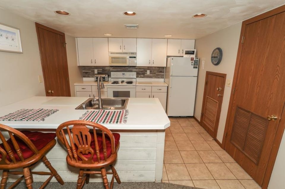 Fully equipped kitchen with modern appliances and breakfast bar, ready for home-cooked meals.