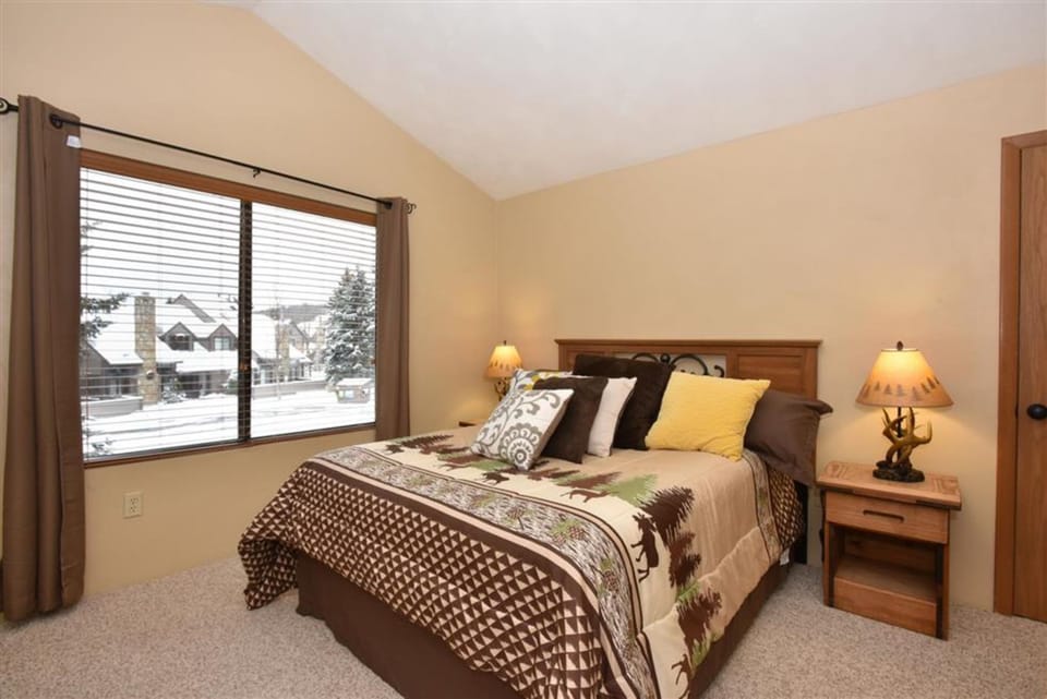 Serene bedroom with plush queen bed, warm lighting, and scenic views right outside your window.