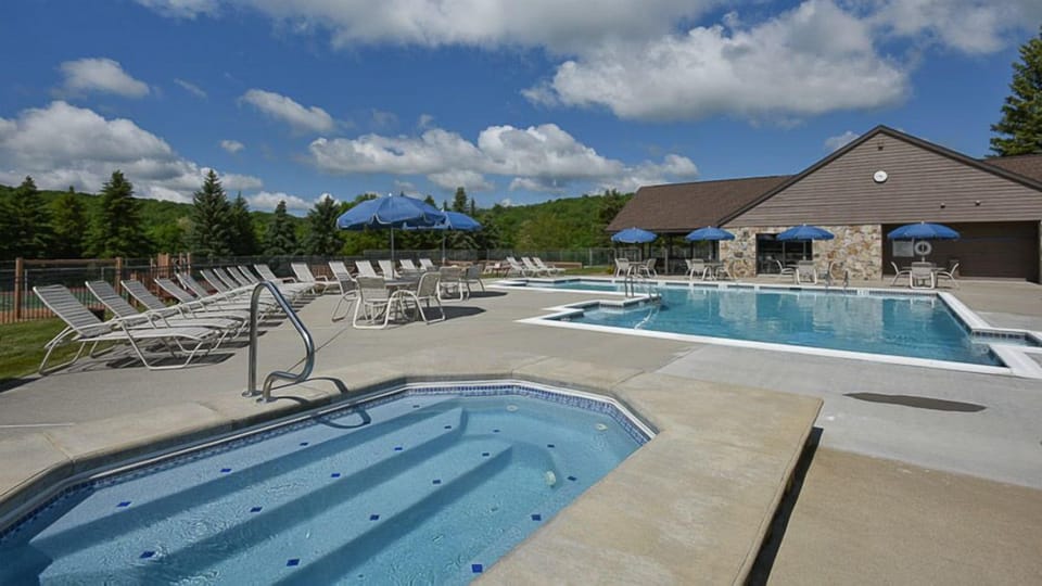 Sparkling outdoor pool surrounded by mountain air and endless blue skies, where summer days unfold in pure relaxation.