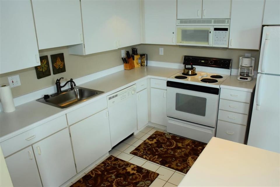 Bright, fully stocked kitchen with white cabinetry and all the essentials for cooking up mountain meals.